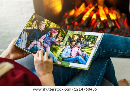 High angle view of young girl looking through photo album at home