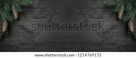Christmas card. Black wood background, with ocreanga and fir cones in the corner, top view. Xmas rectangle congratulation. Royalty-Free Stock Photo #1214769172