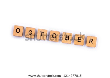 OCTOBER, spelt with wooden letter tiles over a plain white background. 
