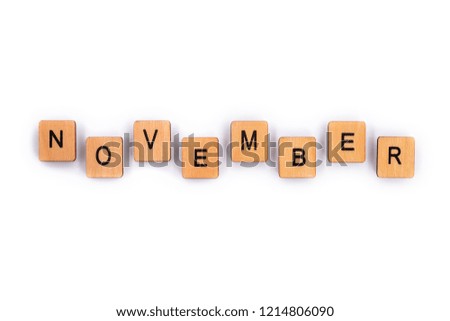 NOVEMBER, spelt with wooden letter tiles over a plain white background. 