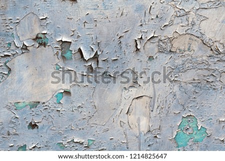 Old cracked abstract grunge vintage texture copy space background, retro pattern. White irregular spots paint peeling of light blue concrete or wooden wall or ceiling flat surface.