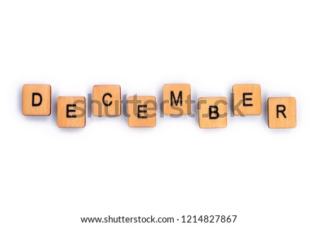 DECEMBER, spelt with wooden letter tiles over a plain white background. 