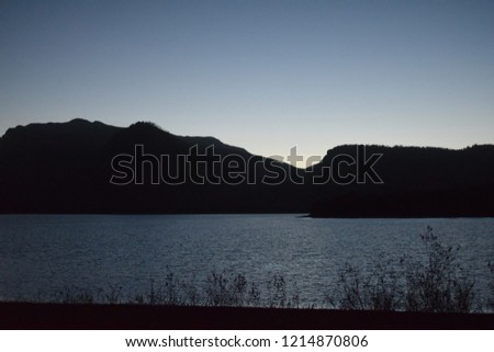 Beautiful picture of the Grand Teton mountains at night, with sunlight reflection on Jackson lake and the silhouette of the mountains at the Grand Teton National Park, USA