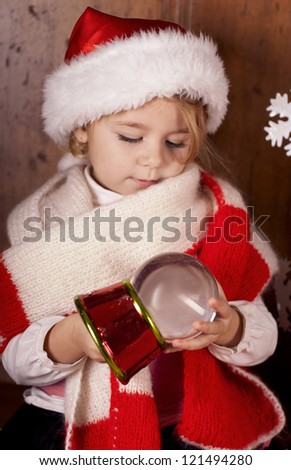 Happy little girl holding a snow globe.