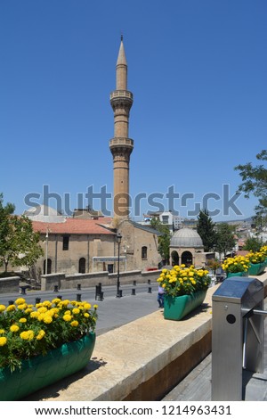 This is a picture of a mosque in Gaziantep ,Turkey 
it's  tall minaret and blue tombs are so standard but still so beautiful 
photo taken on a sunny friday  noon 
everyone  should visit this amazing 
