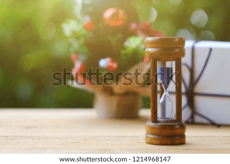 close up hourglass on table, toy pine tree and gift box background, time to holiday season, merry christmas, happy new year 2019
