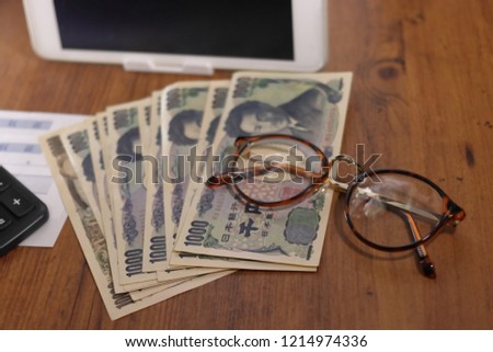 Money and receipt and tablet device and glasses