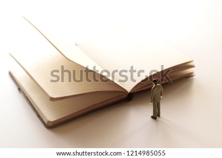 thinking man, miniature people looking at a open notebook