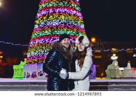 happy man and woman holding hands on Christmas tree background