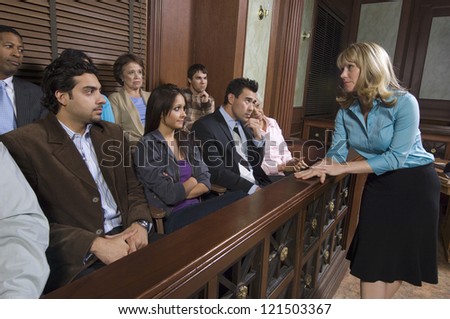 Female advocate talking to the jurors sitting in witness stand at courthouse Royalty-Free Stock Photo #121503367