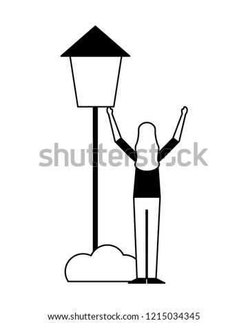 woman standing with post lamp bush