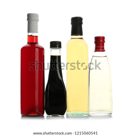 Bottles with different kinds of vinegar on white background Royalty-Free Stock Photo #1215060541
