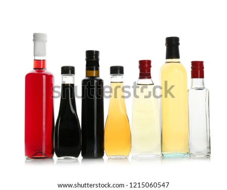 Bottles with different kinds of vinegar on white background Royalty-Free Stock Photo #1215060547