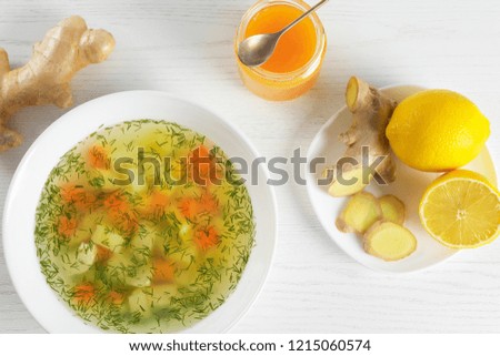 Flat lay composition with bowl of fresh homemade soup to cure flu on wooden background
