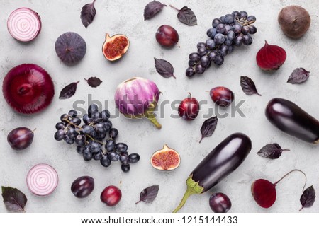 Purple food. Pattern of violet fruits and vegetables on gray concrete background, top view