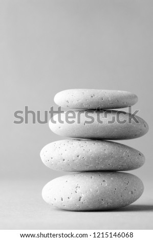 Stack of grey massage stones on gray background.