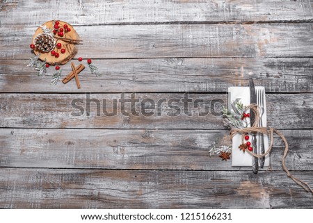 Christmas table place setting with christmas tree branches spoon knife fork and ribbon over wooden table with copy space.