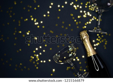 image of champagne coupes and  bottle on dark blue  background 