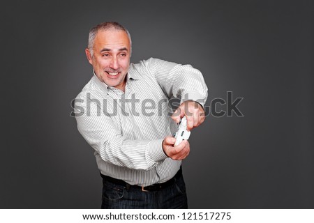 cheerful senior man with joypad over grey background
