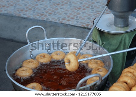 Donuts fried in a pan.

