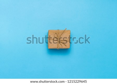 Gift box in craft paper on a blue background. Gift concept for a