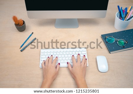 Woman working on her computer. Office morning desk. Morning at a creative studio. Graphic design, mock up screens. glasses, pens, keyboard, notebook, colors, modern.