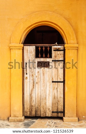 Brown wooden door on a building in orange.