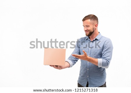 Casual young man holding a box isolated on a white background