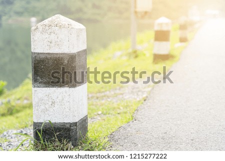 Close up of Black and white milestone with green grass.