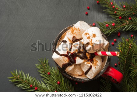 Mug of hot chocolate and coffee with marshmallows with christmas tree branches on black background. Top view.