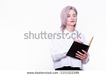 Portrait of young business woman with notepad, making notes in the notebook, standing, writing, takes notes, holding textbook notebook organizer in hand and pen, isolated on white background