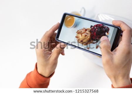 Happy time of young man using smart phone taking photo which take a picture food or bakery before eating, photography on white background