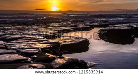 Tide pools with the sun setting in the horizon