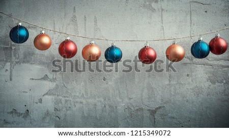Colored Christmas balls hanging on concrete wall background