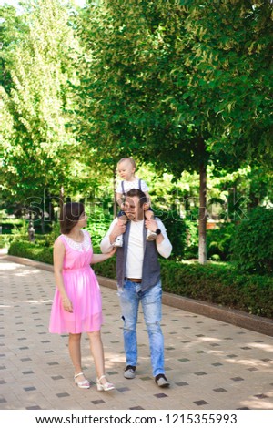 family, parenthood, adoption and people concept - happy mother, father and little boy walking in summer park