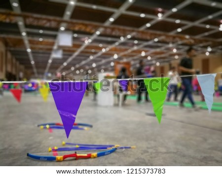 colourful triangular flags of decorated celebrate indoor party with unidentified people in the background.