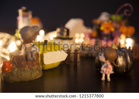 boy and girl at yellow golden pumpkin gate with blank white arrow sign welcome to Halloween festival party house. Festive Celebration, Holidays, Fun, Halloween toy and doll decoration theme concept.