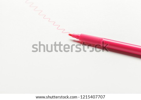 One single felt-tip pen of pink color with drawn color mark on white background