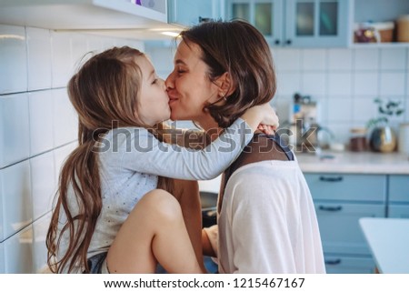 Mom and little daughter having fun together in the kitchen