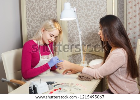 Pretty young woman doing manicure in salon. Beauty concept. Royalty-Free Stock Photo #1215495067