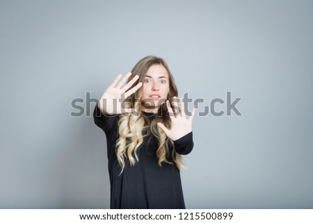 beautiful blonde woman showing stop, I'm scared, isolated on a black background