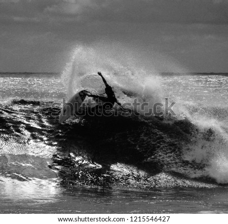 Artistic black and white picture of a surfer at full speed on a big wave