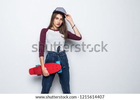 Young girl in cap holding a skateboard and looking at the camera isolated on white background