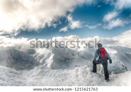 skier stay with skis on big rock on mountains backdrop. Bansko, Bulgaria