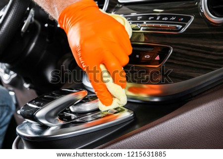 A man cleaning car with microfiber cloth. Car detailing. Selective focus. Car detailing. Cleaning with sponge. Worker cleaning. Microfiber and cleaning solution to clean.  Royalty-Free Stock Photo #1215631885