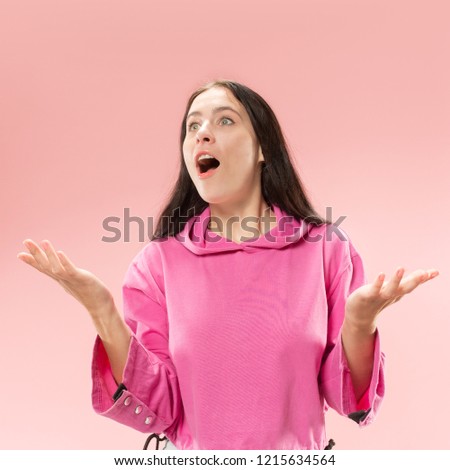 Wow. Beautiful female half-length front portrait isolated on pink studio backgroud. Young emotional surprised woman standing with open mouth. Human emotions, facial expression concept. Trendy colors
