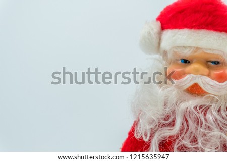 Santa Claus toy figure with silver bell on his hand isolated on white background.