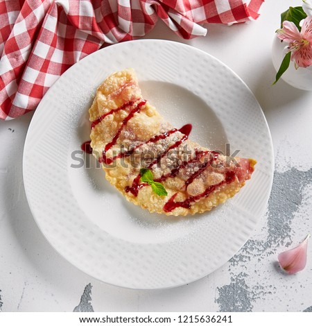 Sweet Berry Cheburek with Confiture, Powdered Sugar and Mint Top View. Thinly Rolled Deep Fried Crispy Pie, Qutab or Turnover Stuffed with Strawberry Jam and Raspberries Flat Lay Close Up
