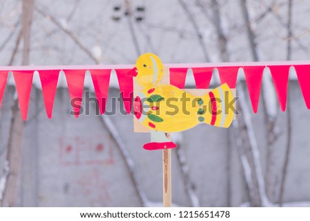 Children toy - wooden painted duck on a stick outdoors. Backyard decoration. 