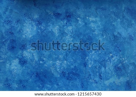 An abstract, painted blue background with an uneven surface